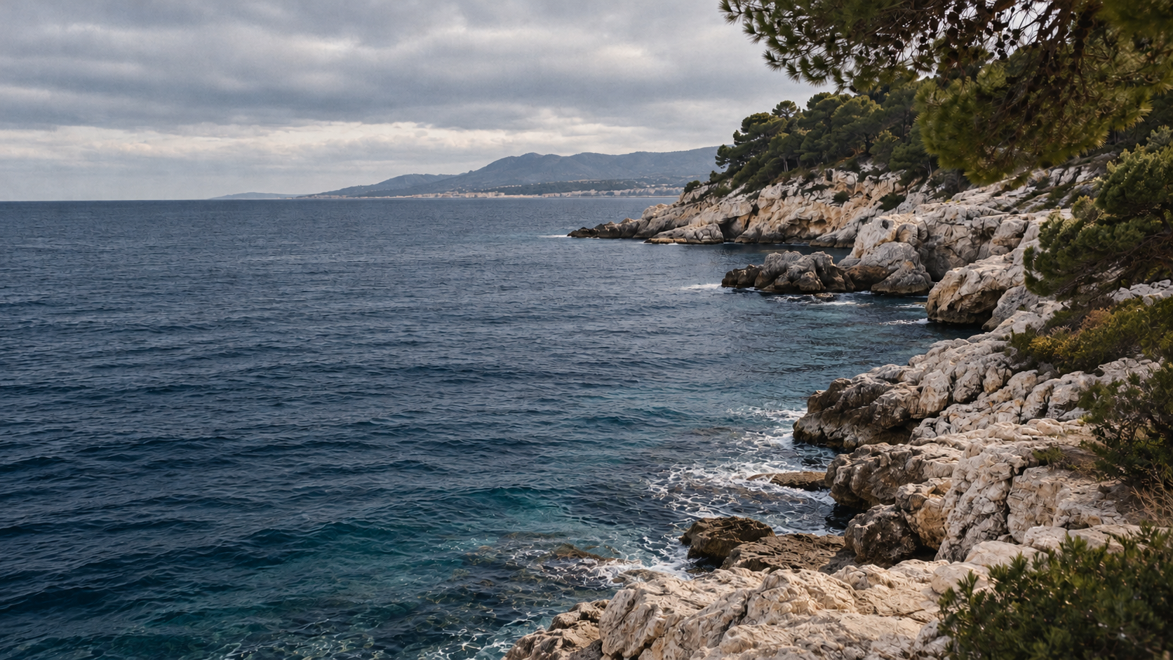 Una cala de piedra y pinos frente al Mediterráneo en un día de otoño